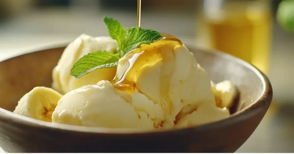 Scoops of banana ninja creami dessert drizzled with honey and garnished with fresh mint.