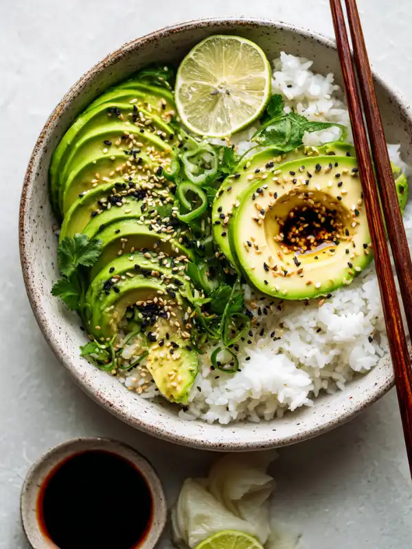 Completed avocado rice bowl with chopsticks and garnish