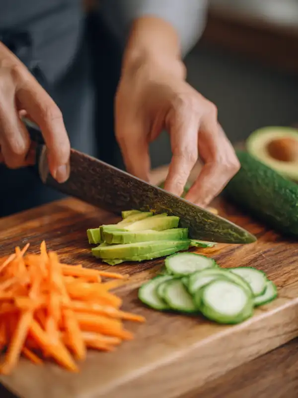 Preparing avocado, cucumber, and carrot slices on cutting board